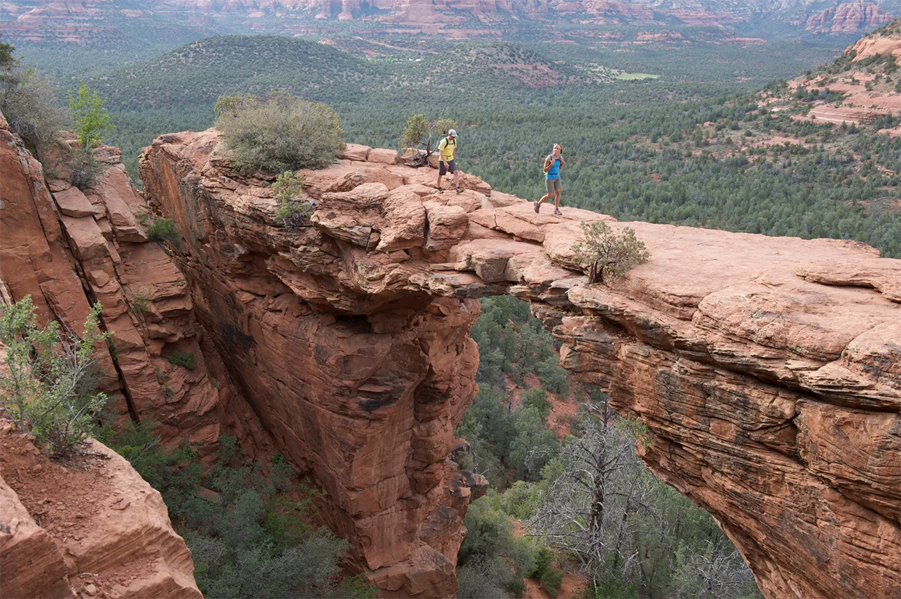 Two hikers walk over rocky terrain at high elevation