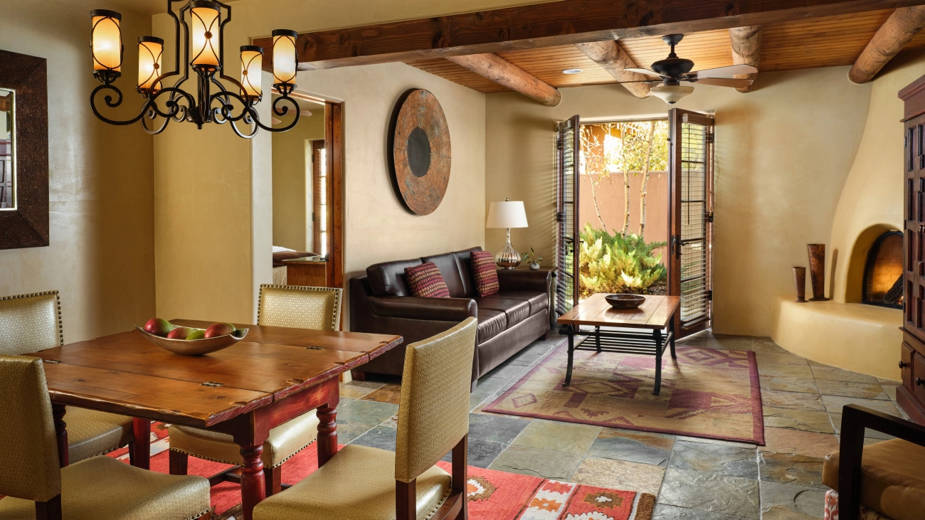 Southwestern-style living and dining room with an adobe-style fireplace, and patio