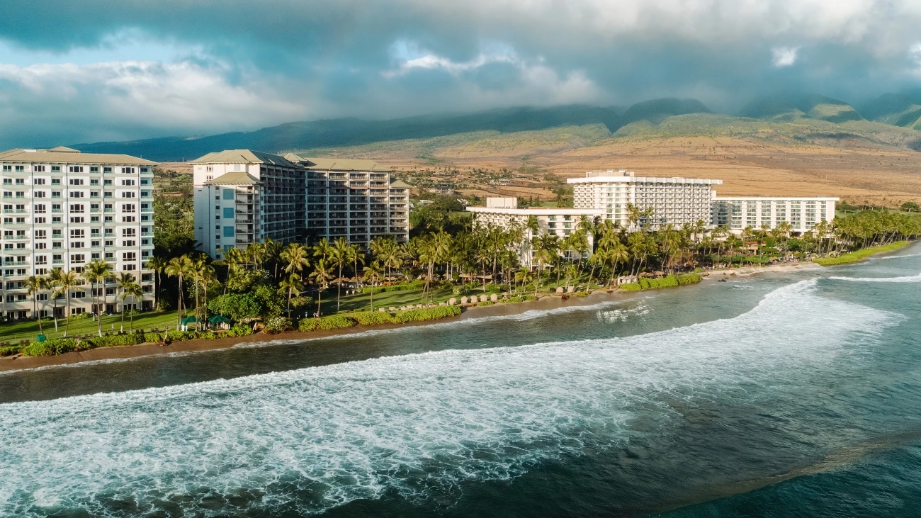 Beach resort in Hawaii with lush, rolling mountains in the background
