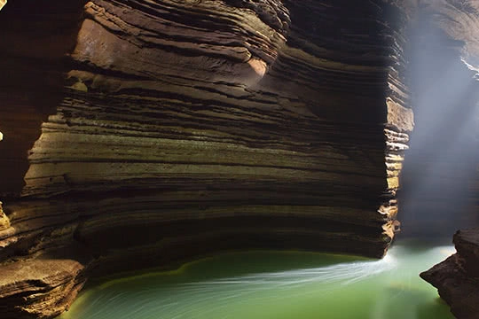 Swirled rocks are lit up as a river runs through it