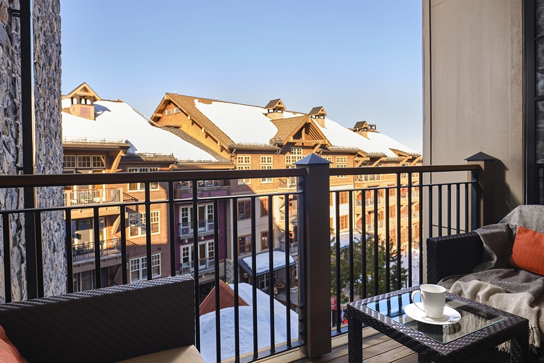 Chairs and a table sit on a villa's outdoor patio overlooking the resort