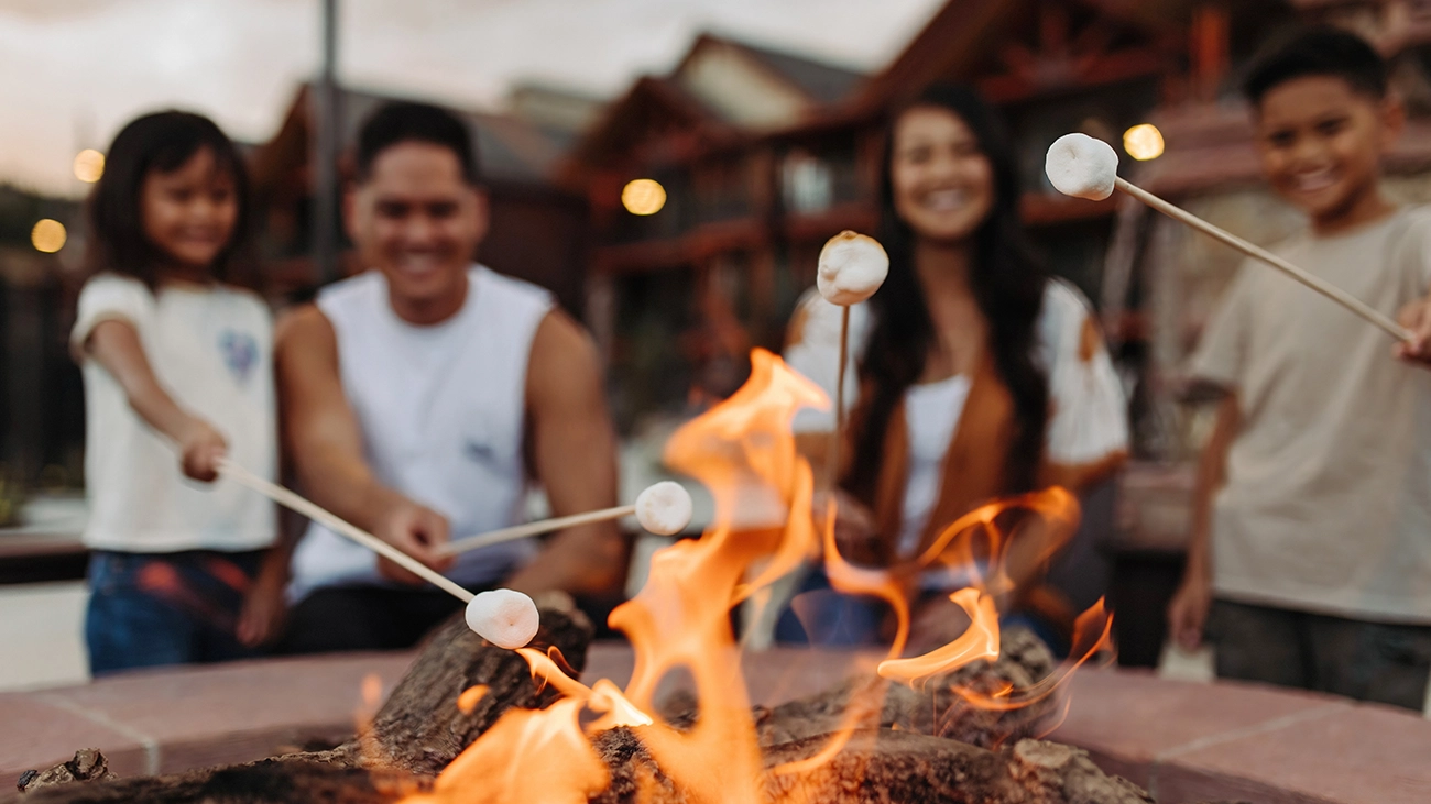 A family toasts marshmallows around the fire pit