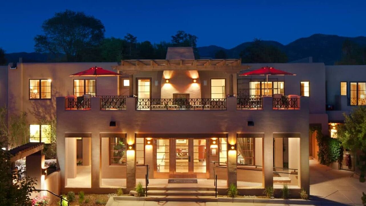 The Residences at El Corazón de Santa Fe brightly lit at dusk
