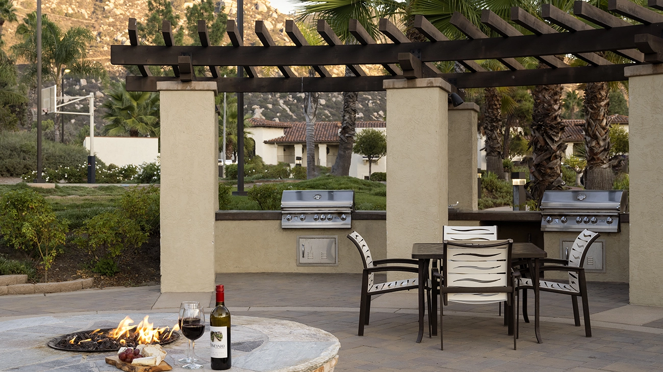 Patio with fire pit, chairs, tables, and a grill